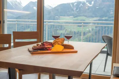 a table with a plate of food and two glasses of wine at Jaufnerhof in Mareta