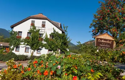 a white building with flowers in front of it at Appartementhaus Lechnerhof in Brunico