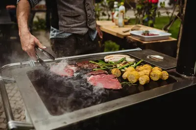 a man is grilling meat and vegetables on a grill at Chalet Passeier - ZOLL in Saltusio