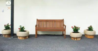 a wooden bench sitting in front of a white wall with two potted plants at Villa Gottfried Appartment in Eggen