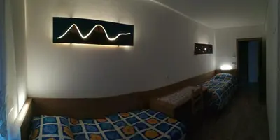a room with two beds and a sign on the wall at CASA RAINA in Castelfondo