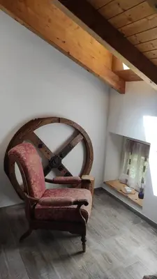 a chair sitting in a room with a fireplace at CASA RAINA in Castelfondo