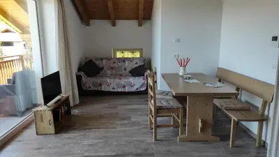 a living room with a table and a couch at CASA RAINA in Castelfondo