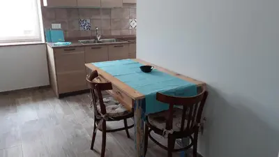 a kitchen with a blue table and two chairs at CASA RAINA in Castelfondo
