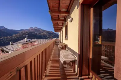 a balcony with a bench on the side of a building at NeveSole Chalet - Charming Flat Near Dolomiti Ski Slopes in San Vito di Cadore