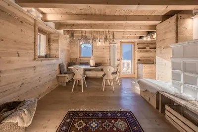 a room with wooden walls and a table and chairs at NeveSole Chalet - Charming Flat Near Dolomiti Ski Slopes in San Vito di Cadore