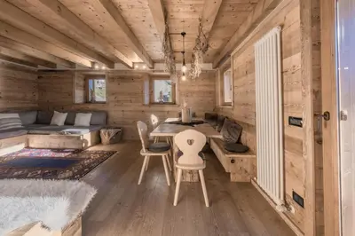 a room with a table and chairs in a tiny house at NeveSole Chalet - Charming Flat Near Dolomiti Ski Slopes in San Vito di Cadore