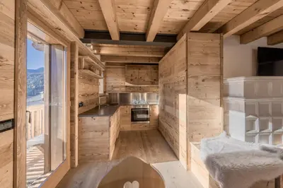 a kitchen with wooden walls and a large window at NeveSole Chalet - Charming Flat Near Dolomiti Ski Slopes in San Vito di Cadore