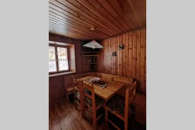 a dining room with a wooden table and chairs at Casa Bel Vedere in Falcade