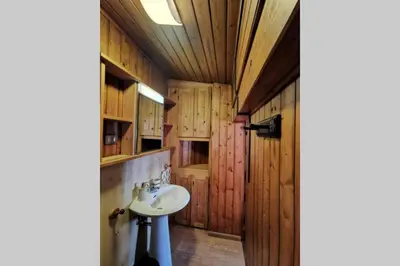 a bathroom with a sink and wooden cabinets at Casa Bel Vedere in Falcade