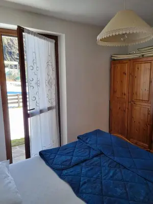 a bedroom with a bed and a sliding glass door at Appartamento con giardino in Predazzo