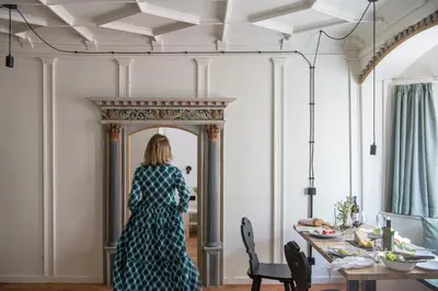 a woman standing in front of a mirror in a room at Ida - historic town apartments in Vipiteno