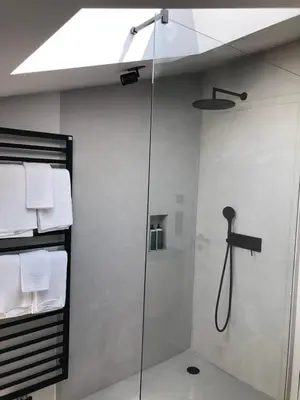 a shower with a glass door in a bathroom at Ida - historic town apartments in Vipiteno