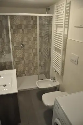 a bathroom with a toilet and a sink and a shower at Casa Tania in Pozza di Fassa