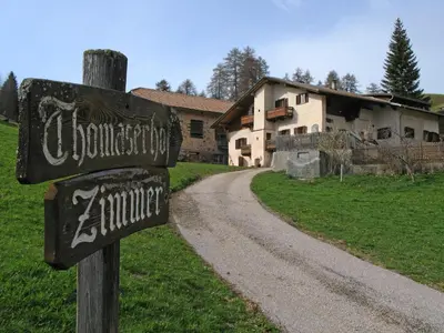 a sign on a dirt road in front of a house at THOMASERHOF in Redagno