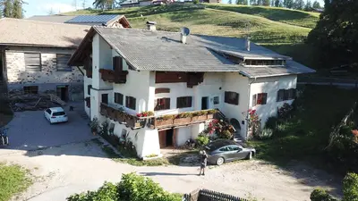 a woman standing in front of a white house at THOMASERHOF in Redagno