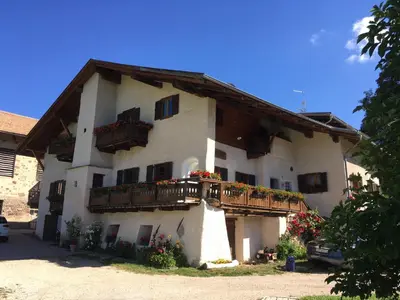 a building with a balcony and flowers on it at THOMASERHOF in Redagno