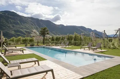a room with a dining table and a bed at Boutique Hotel Wiesenhof - Adults Only in Lana