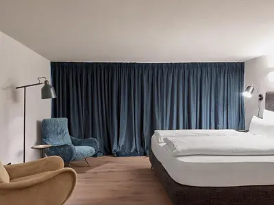 a bedroom with a bed and a chair and a window at Parcloft in Merano