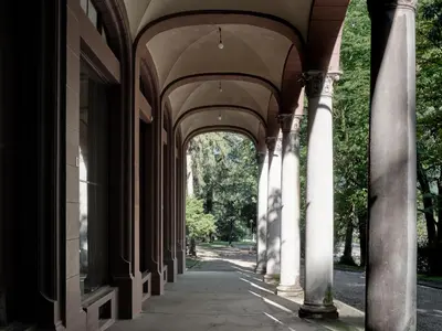 an arcade of an old building with columns at Parcloft in Merano