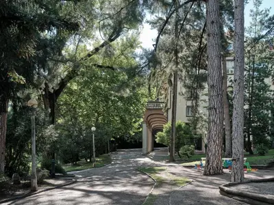 a building with an arch in a park with trees at Parcloft in Merano