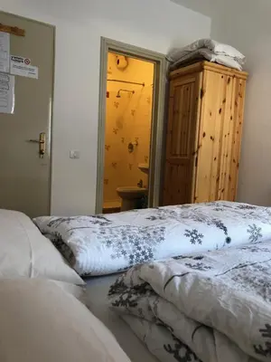 a bedroom with two beds and a mirror at B&B Astor in Alleghe