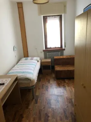 a small room with a bed and a window at B&B Astor in Alleghe