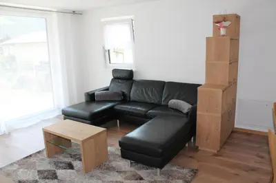 a living room with a black leather couch and a coffee table at Garni Wiesenhof in Naturno
