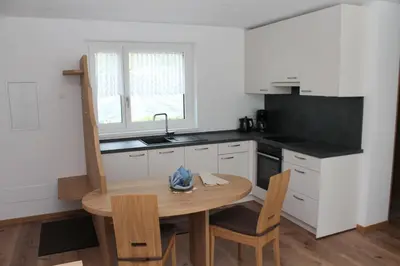 a small kitchen with a wooden table and a sink at Garni Wiesenhof in Naturno
