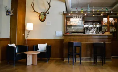 a bar with black chairs and a table at Park Hotel Sancelso in Bellamonte