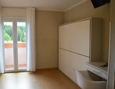 a kitchen with a white refrigerator and a sliding glass door at Park Hotel Sancelso in Bellamonte