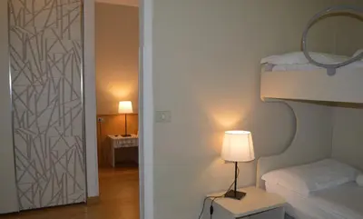 a bedroom with a bed and a mirror and a lamp at Park Hotel Sancelso in Bellamonte