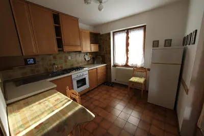a small kitchen with wooden cabinets and a window at Cesa Roseda in Canazei