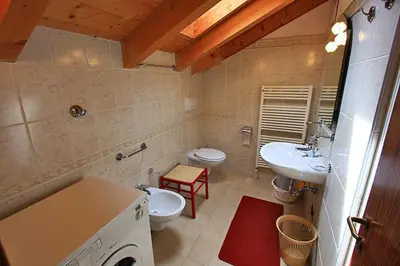 a bathroom with two toilets and a sink and a toilet istg at Cesa Roseda in Canazei