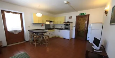 a kitchen with a table and chairs in a room at Cesa Roseda in Canazei