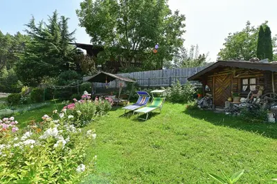 a garden with two lawn chairs and a shed at Lärchenheim Appartment in Castelrotto