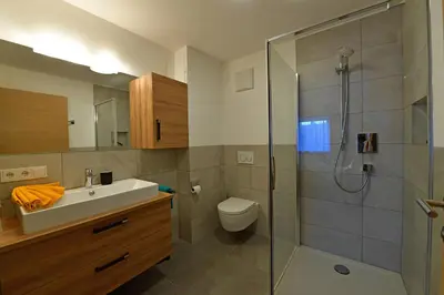 a bathroom with a sink toilet and a shower at Lärchenheim Appartment in Castelrotto