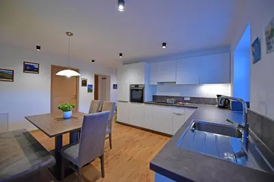 a kitchen and dining room with a table and a sink at Lärchenheim Appartment in Castelrotto