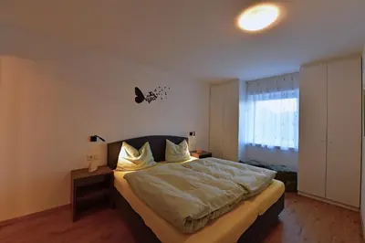 a bedroom with a large bed and a window at Lärchenheim Appartment in Castelrotto