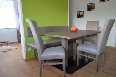 a dining room table with chairs and a bowl of fruit on it at Lärchenheim Appartment in Castelrotto