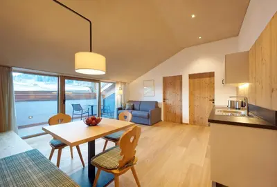 a kitchen and living room with a table and chairs at Ansitz Lidl in Tesimo