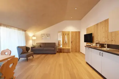 a kitchen and living room with a couch and a television at Ansitz Lidl in Tesimo