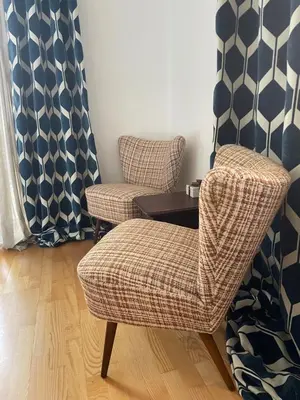 a living room with two chairs and a table at Villa Maria Dolomites Vintage Home in Brunico