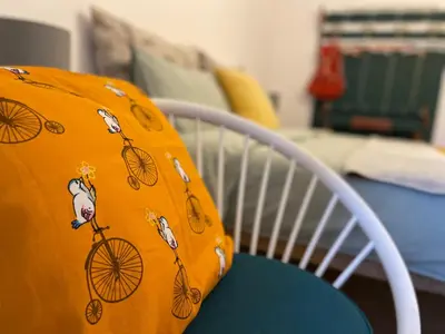 an orange blanket sitting on top of a white chair at Villa Maria Dolomites Vintage Home in Brunico