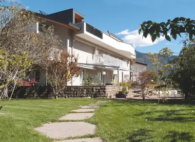 a house with a stone walkway in front of it at Ausserdorfer Apartments in Lana