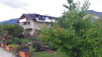 a house with a lot of plants in front of it at Ausserdorfer Apartments in Lana