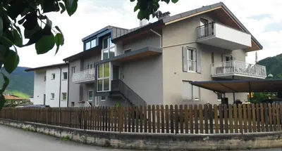 a building with a fence in front of it at Ausserdorfer Apartments in Lana