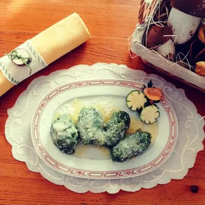 a plate of broccoli on a wooden table at Hotel Edelweiss in Val di Zoldo