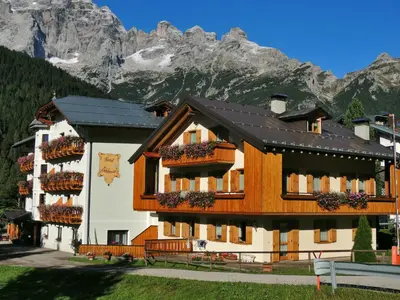 a hotel in the mountains with mountains in the background at Hotel Edelweiss in Val di Zoldo