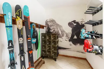 a room with skis and snowboards on a wall at Hotel Edelweiss in Val di Zoldo